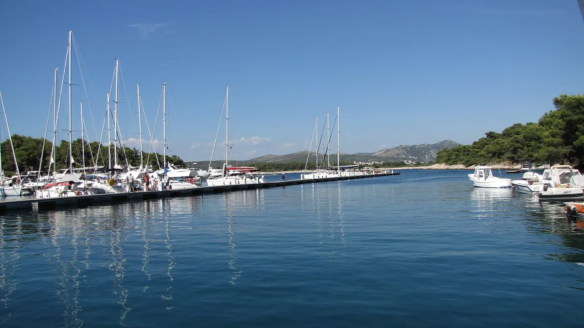 Yachts on the main pontoon of ACI Marina Palmižana in Luka Palmižana on Sveti Klement, looking out of the cove toward Hvar
