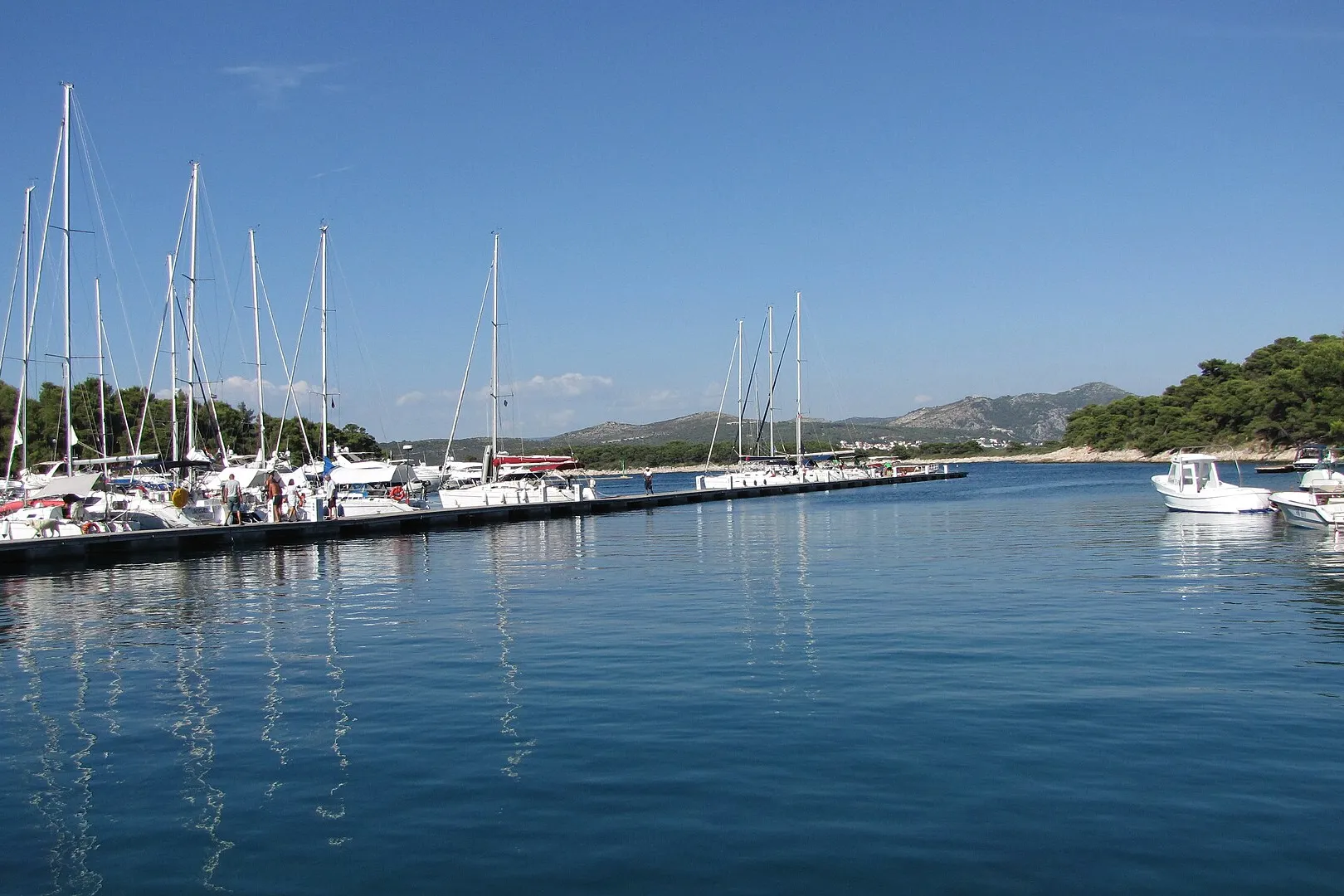 Yachts on the main pontoon of ACI Marina Palmižana in Luka Palmižana on Sveti Klement, looking out of the cove toward Hvar