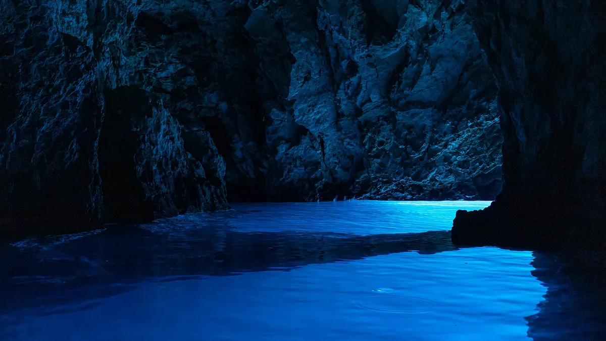 Light glowing blue on the water inside the Blue Cave (Modra špilja)