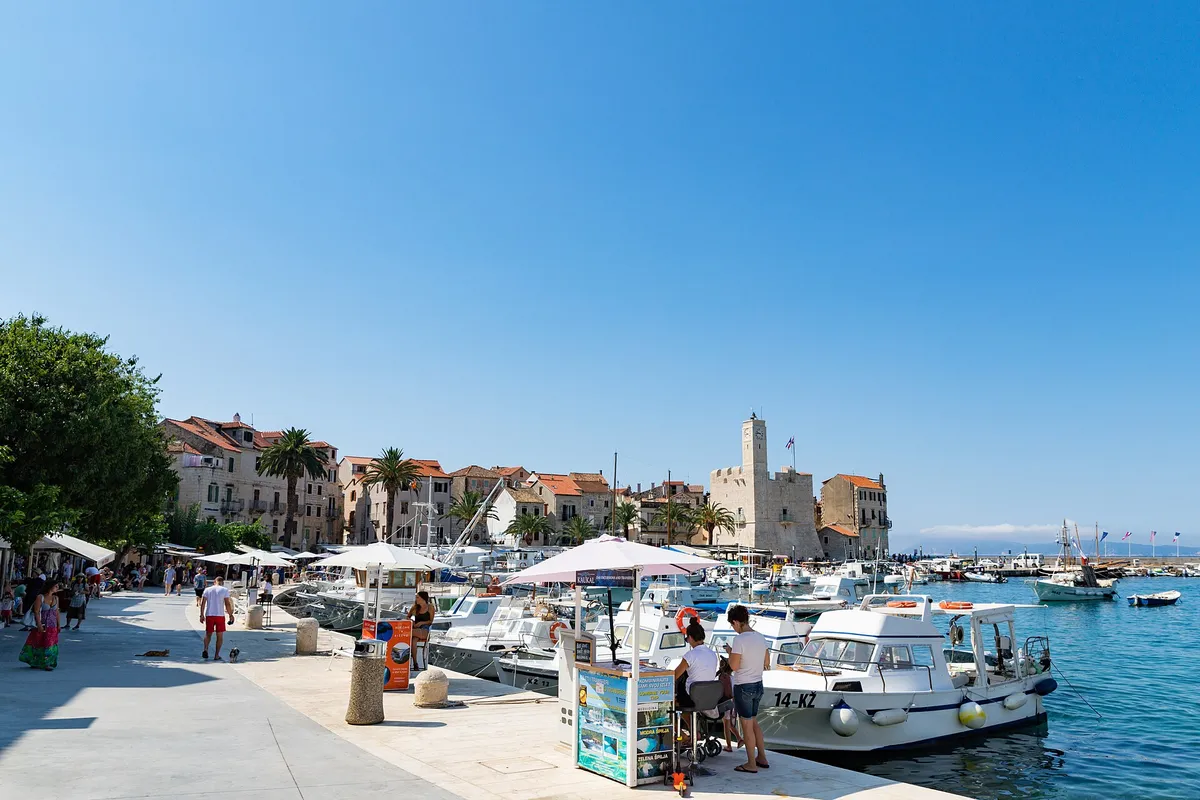 The Komiža waterfront with the Kaštel tower, which holds the fishermen's museum, and local boats along the quay.
