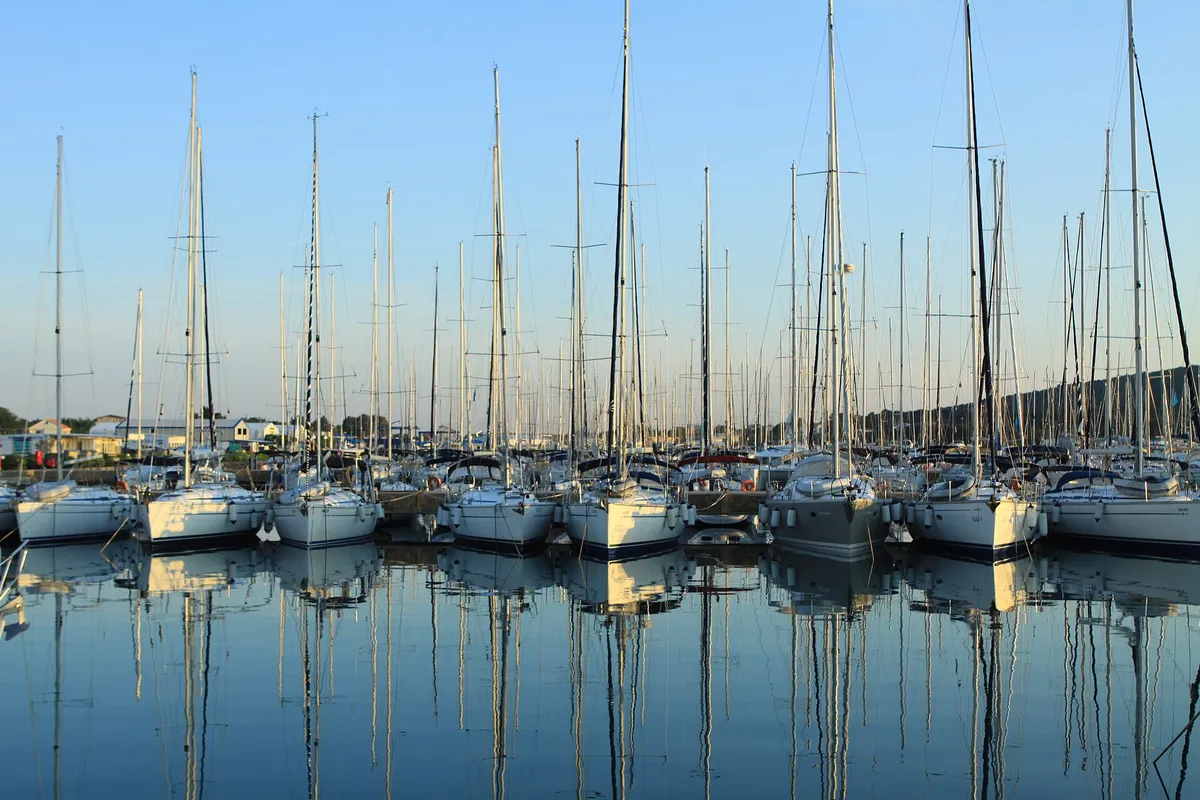 Rows of charter yachts on the pontoons of D-Marin Dalmacija near Zadar, their masts reflected in still water