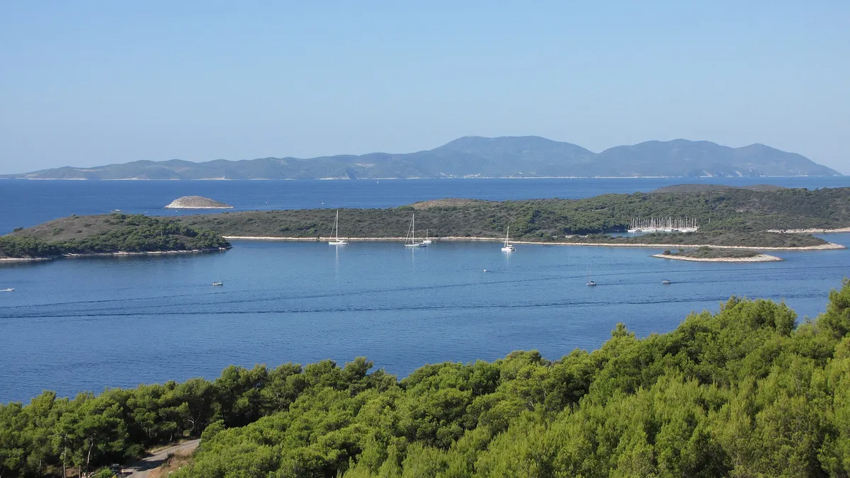 The Pakleni islands and ACI Marina Palmižana from the hills above Hvar town, yachts at anchor, Vis on the horizon