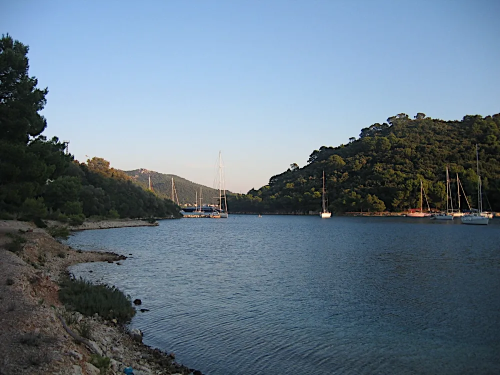 Yachts at their moorings in the bay at Pasadur on Lastovo on a calm evening, between wooded hills