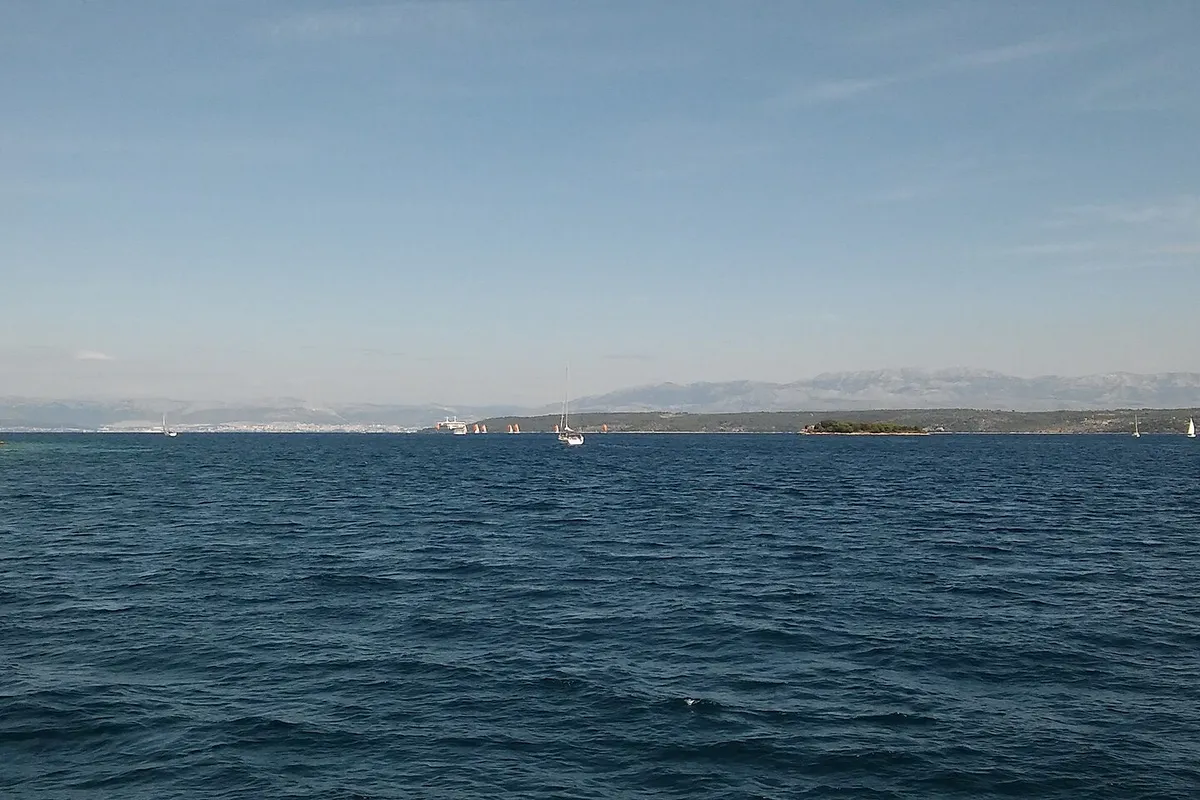 The Split Gate, the strait between Šolta and Brač, seen from the sea, with a small lighthouse and the mainland mountains beyond