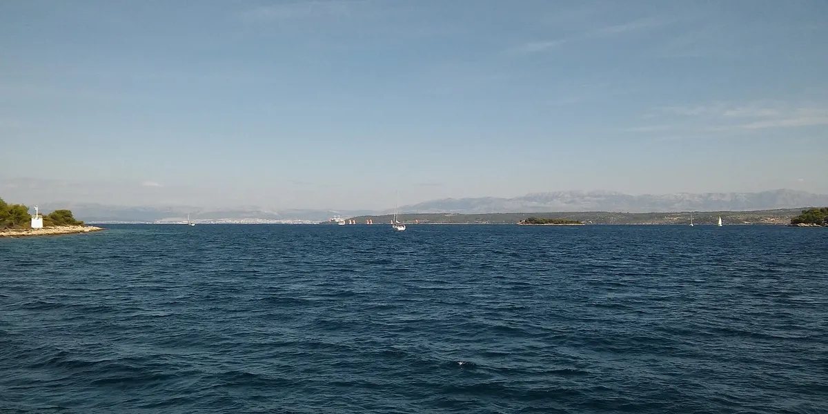 The Split Gate, the strait between Šolta and Brač, seen from the sea, with a small lighthouse and the mainland mountains beyond