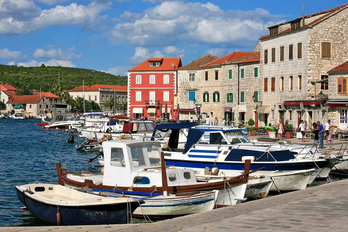 Local boats and motorboats along the stone quay in Stari Grad harbour