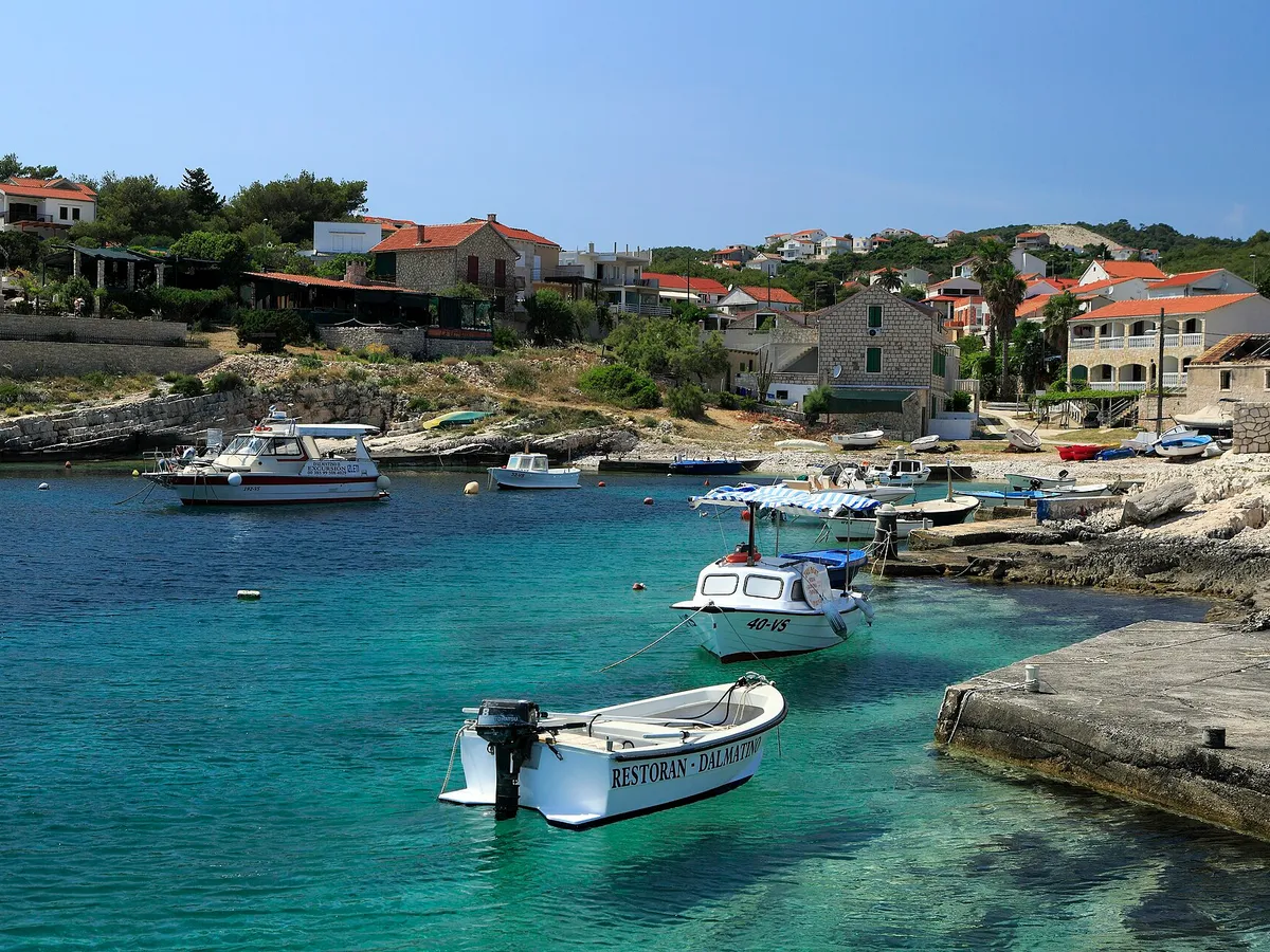 Small local boats in the clear turquoise bay at Rukavac