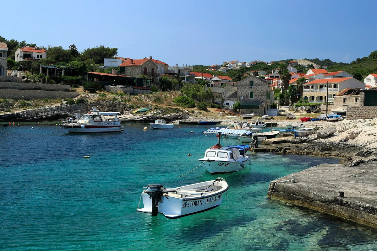 Small local boats in the clear turquoise bay at Rukavac
