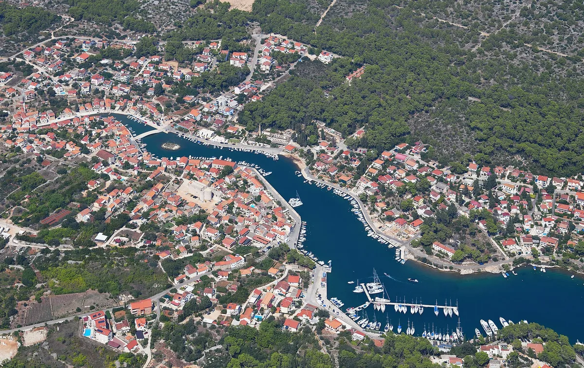 Vrboska from the air: the long narrow bay running up into the village, its bridges and quays, and the marina pontoons of ACI Marina Vrboska near the mouth