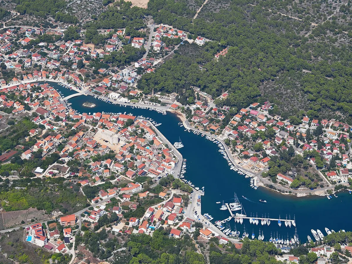 Vrboska from the air: the long narrow bay running up into the village, its bridges and quays, and the marina pontoons of ACI Marina Vrboska near the mouth